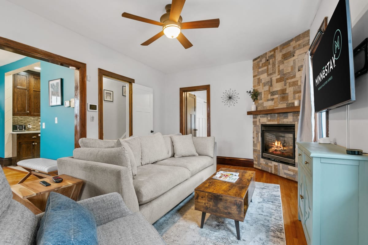 Unwind in this inviting living space where cozy sofas meet the warmth of a crackling fireplace, perfect for your evening relaxation.