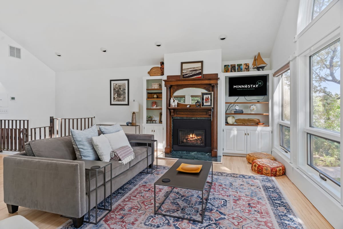 Unwind in your bright living room with cozy fireplace, plush seating, and stunning windows that frame peaceful views.