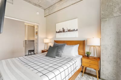 Cozy bedroom featuring wooden furniture, a city skyline artwork, and a soft color palette.