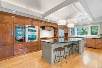 Stylish kitchen with wood cabinets, granite island, and large windows.