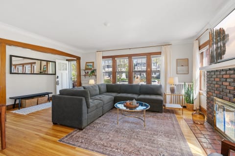 Bright living room with a gray sofa, coffee table, and naturalistic decor.