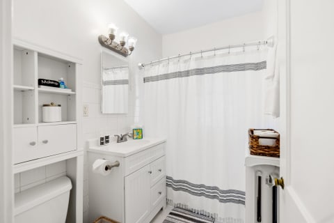 Modern bathroom with white walls, sleek vanity, and organized storage.