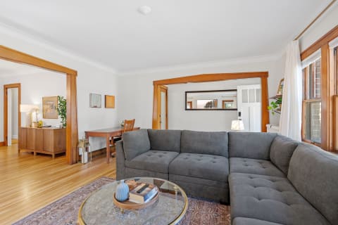 Cozy living room with a dark gray sectional sofa and wooden furniture.