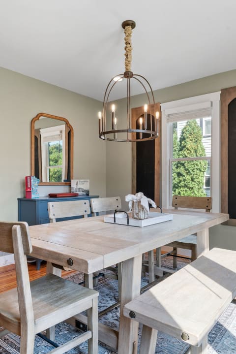 Cozy dining area featuring a wooden table, benches, and an industrial chandelier