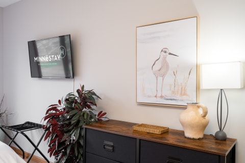Cozy vacation home interior with shorebird artwork, lamp, and decorative vase.