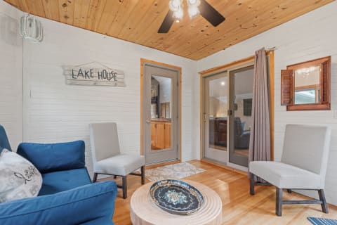 Interior of a lake house corner with a blue sofa, a grey chair, and a wooden coffee table.
