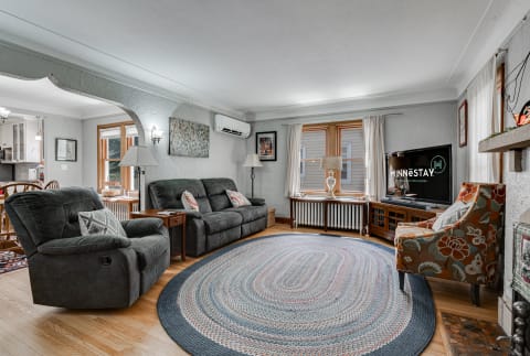 Cozy living room with dark gray recliners, a braided rug, and a flat-screen TV.