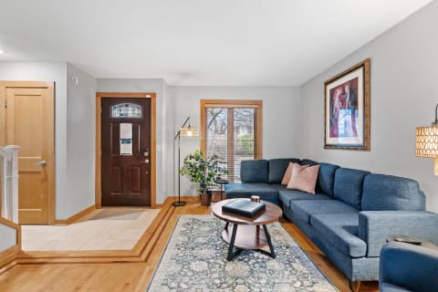 Cozy living room featuring a blue sectional sofa, round coffee table, and plants.