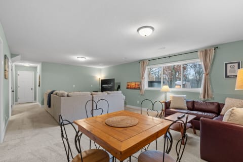 A cozy basement living area featuring a dining table and seating options.