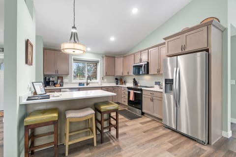A bright modern kitchen featuring light cabinets and a stylish pendant light.