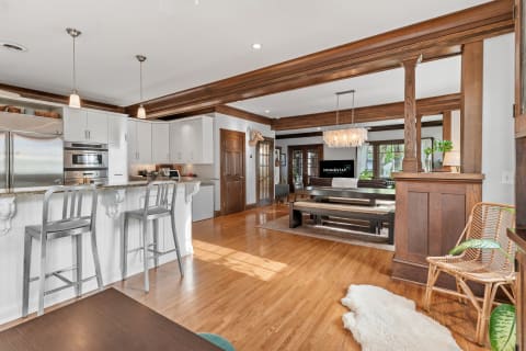 A bright and modern living area with kitchen, featuring rich wood accents and contemporary furnishings.