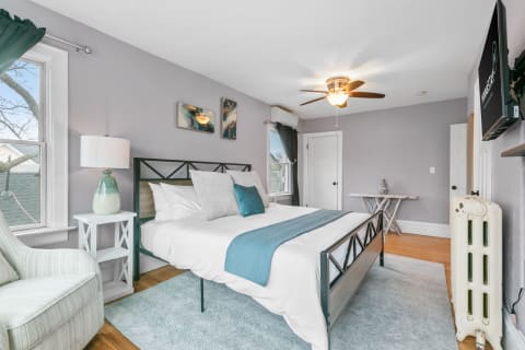 Cozy bedroom with a bed, accent pillows, and green curtains.