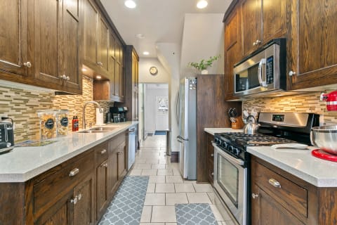 Contemporary kitchen with wooden cabinets, stainless steel appliances, and a mosaic backsplash.