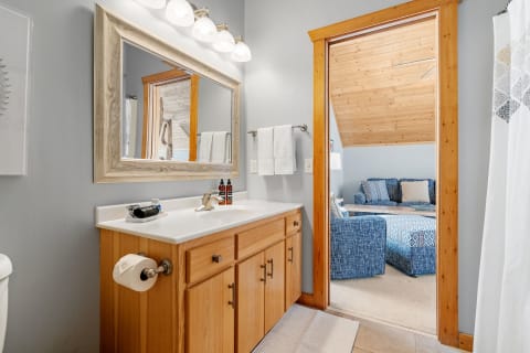 Interior view of a modern bathroom leading to a living area.