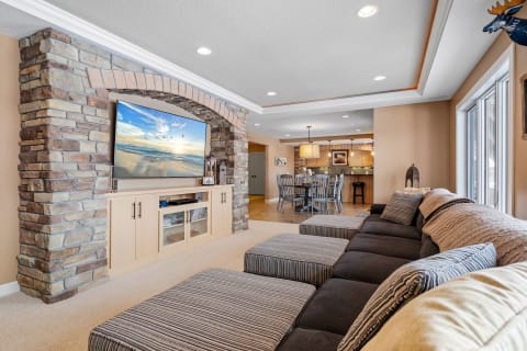 Spacious living room featuring a sectional sofa, a stone archway, and a dining area.