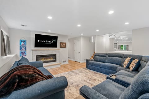 Modern living room with blue sectional sofa, fireplace, and TV.
