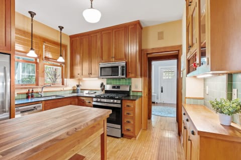 A well-designed kitchen with wooden cabinetry, granite countertops, and stainless steel appliances.