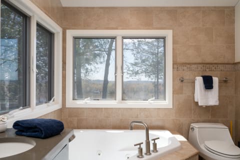 Modern bathroom with a luxurious bathtub and a view of nature.