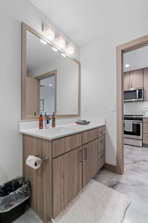 Contemporary bathroom featuring a white countertop and wooden vanity.