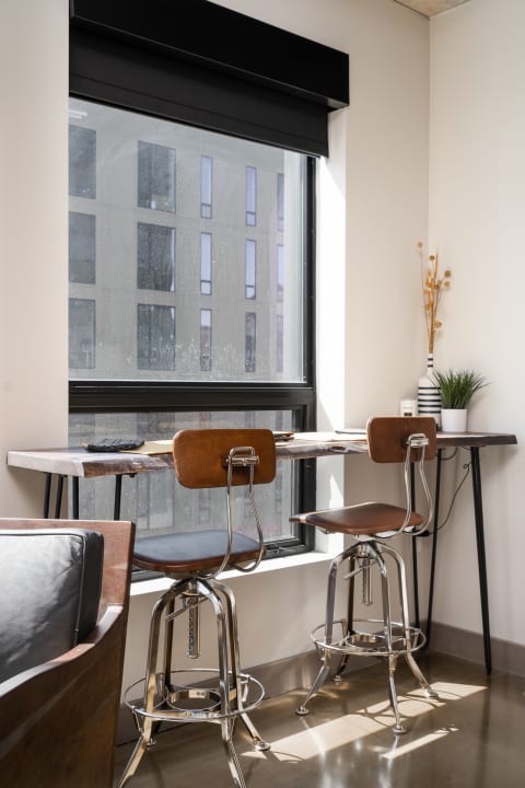 Interior space featuring bar stools and a wooden table by a window.