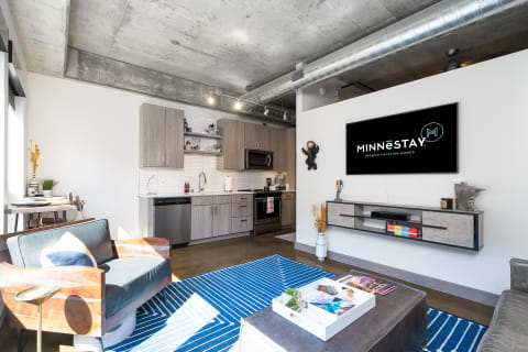 A stylish modern living room featuring a kitchen and cozy seating area.