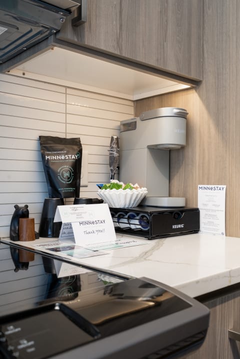 A cozy kitchenette featuring a coffee maker, coffee accessories, and a thank you note.