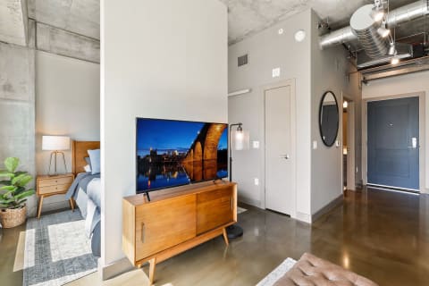 Interior view of a modern studio apartment with a bed and television.