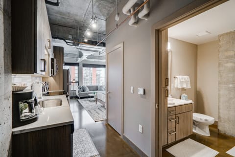 Interior view of a stylish apartment showcasing a kitchen, living area, and bathroom.