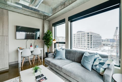 Cozy living room featuring a grey sofa, modern decor, and a view of the city.
