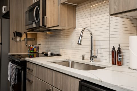 Contemporary kitchen with wooden cabinets, stainless steel sink, and sleek countertop.