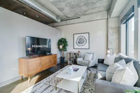 Cozy modern living room with a gray sofa, a wooden media console, and a stylish coffee table.