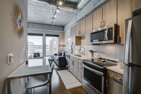 Interior view of a modern kitchen combined with a living space in a stylish apartment.