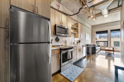Modern kitchen with stainless steel appliances and a cozy living area.