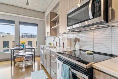Modern kitchen with stainless steel appliances and a table adorned with yellow tulips.