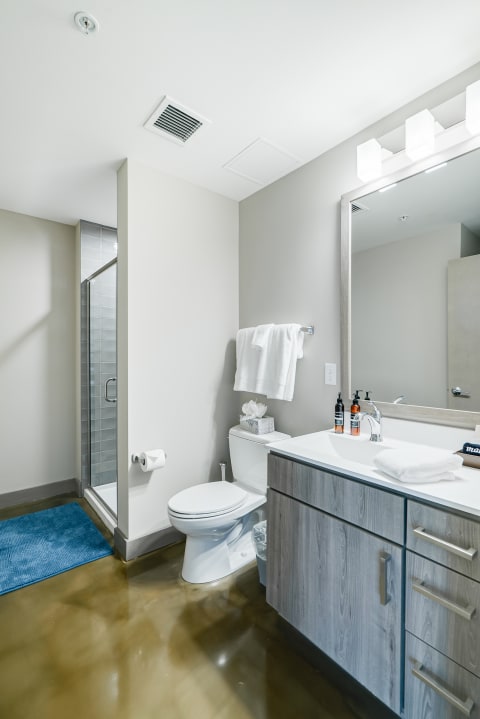 A clean and modern bathroom with a shower, toilet, and vanity.