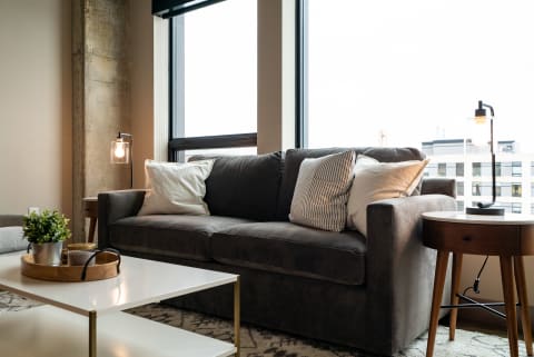 Gray couch in a modern living room with a floor lamp and coffee table.