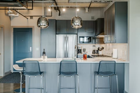 Modern kitchen with a white marble countertop, metallic accents, and elegant appliances