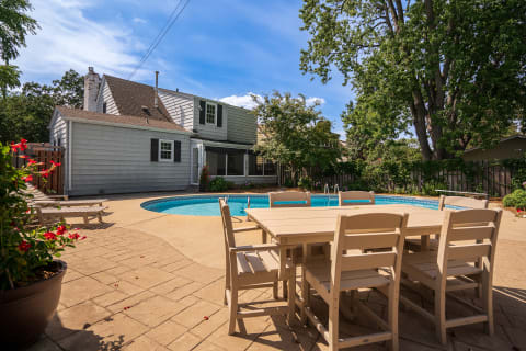 Backyard view featuring a pool and outdoor dining table.