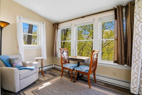 Settle into this cozy nook where sunlight and treetop views frame your morning coffee or afternoon read, offering a peaceful retreat within your home away from home.