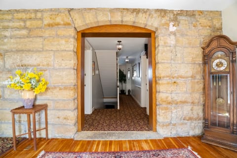 The entryway's historic stonework and warm wooden floors invite you in, while classic décor and soft lighting set a welcoming, timeless tone from the moment you arrive.