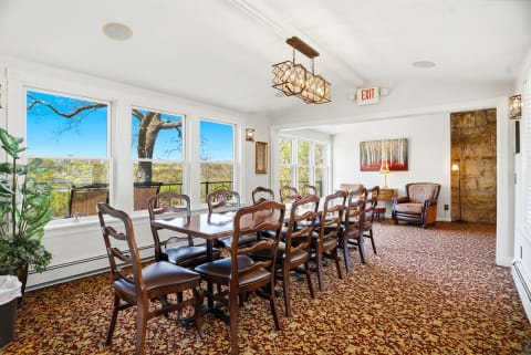 Gather around the elegant dining table and enjoy sweeping views of rolling hills through expansive windows, where natural light fills this beautifully appointed space perfect for memorable meals together.