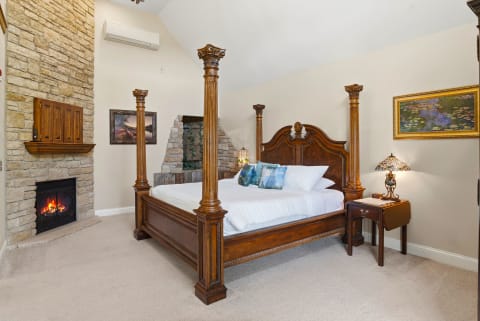Drift off in this elegant four-poster bed with crisp linens, warmed by a cozy fireplace and cooled by climate control—your perfect blend of comfort and charm.