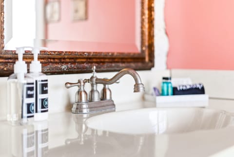 Freshen up at your private vanity with elegant fixtures, a framed mirror, and complimentary amenities thoughtfully arranged for your comfort.