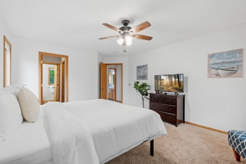 Cozy bedroom with a large bed, TV, and decorative elements.