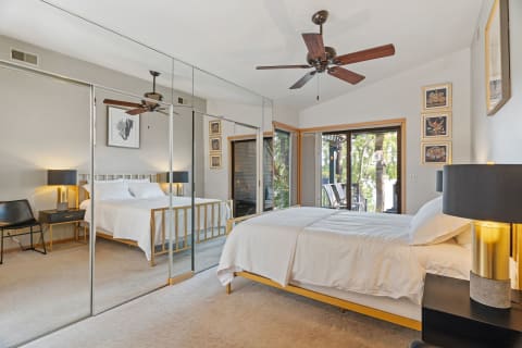 A stylish bedroom with a bed, bedside tables, and a balcony view.