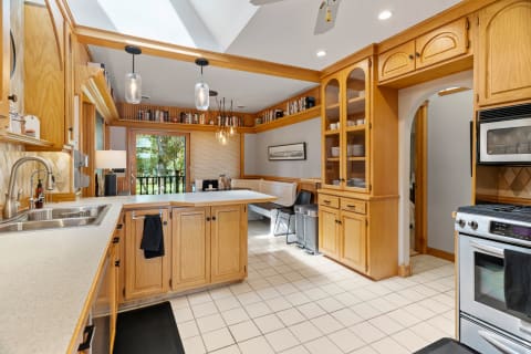 A cozy kitchen with wooden cabinets, bright lighting, and a breakfast nook.
