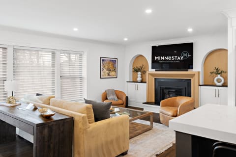 Modern living room design with large windows, beige sofa, and a sleek fireplace.