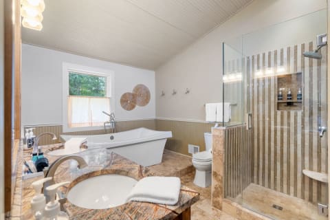 Modern bathroom design with freestanding bathtub, dual sinks, and glass shower.