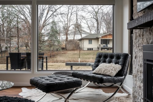 Sink into this luxurious leather chair where natural light streams through floor-to-ceiling windows, creating your perfect reading retreat.