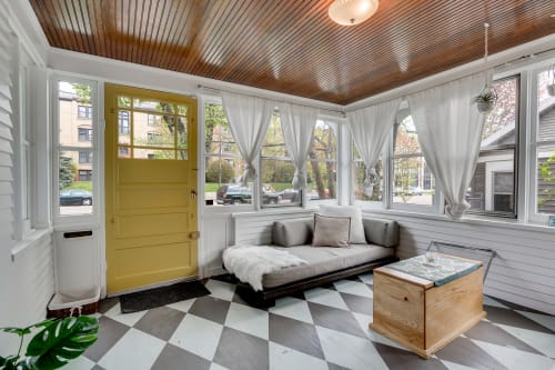 Relax in this bright sunroom with stunning wood ceilings, cozy seating, and neighborhood views through floor-to-ceiling windows.